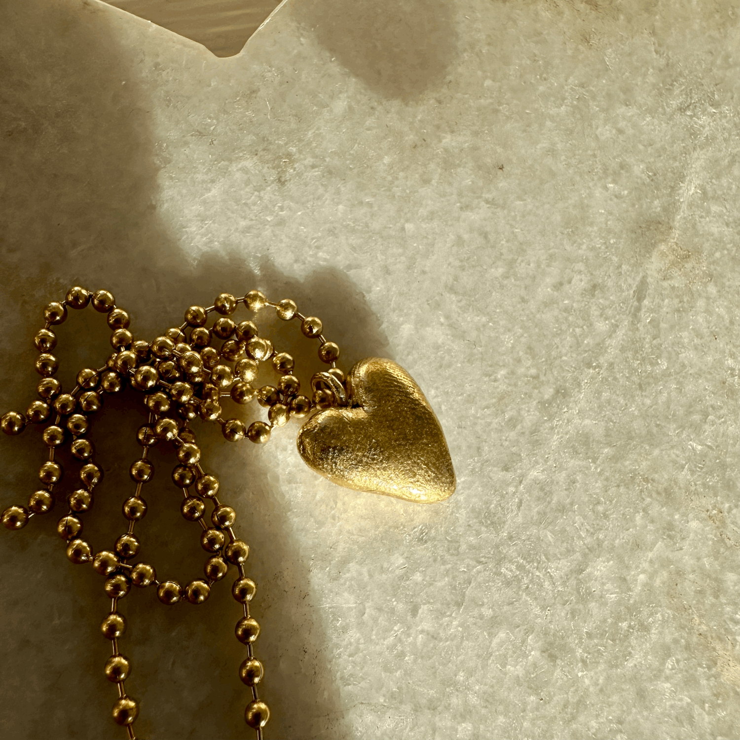 Heart Pendant: A hand carved solid recycled brass heart charm on a long brass ball chain.