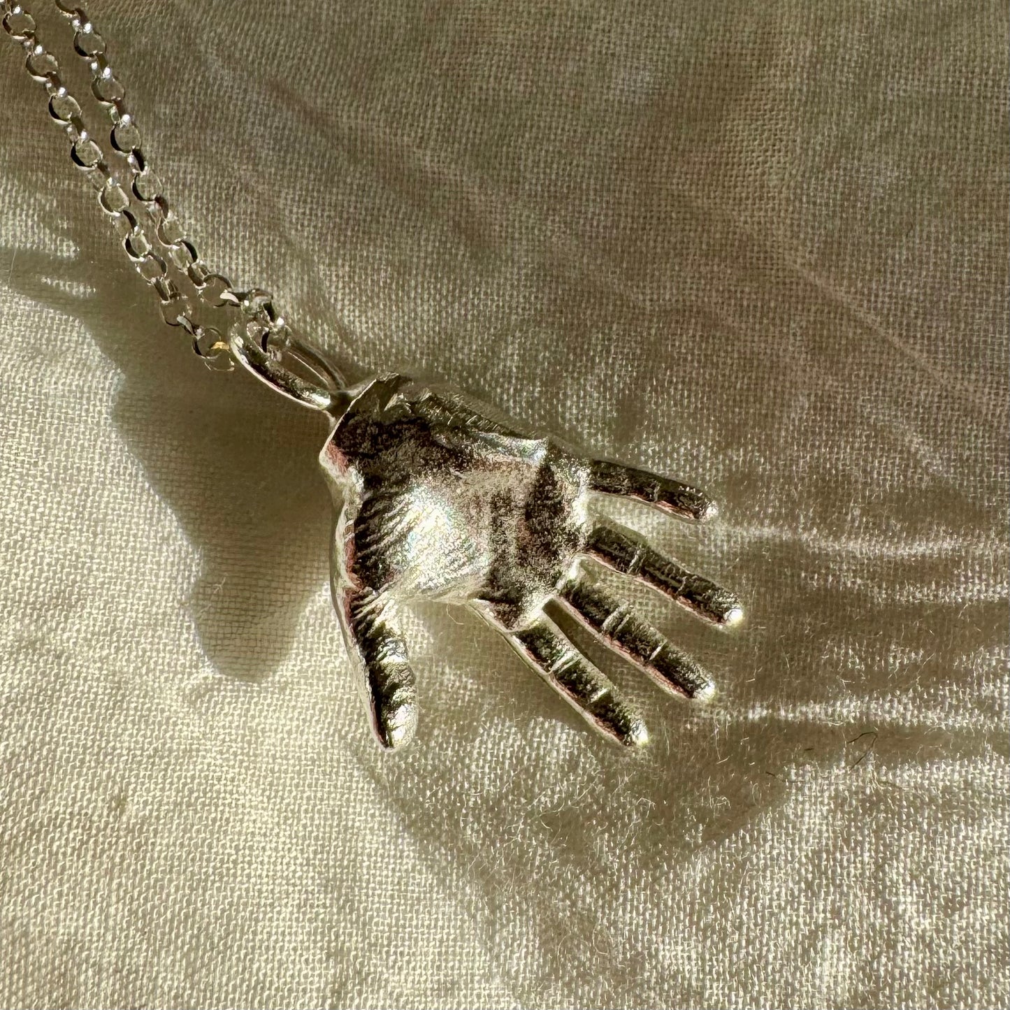 A little Hand charm cast in recycled silver and measuring 2cm by 1.5cm hanging on a 45cm recycled silver chain.
