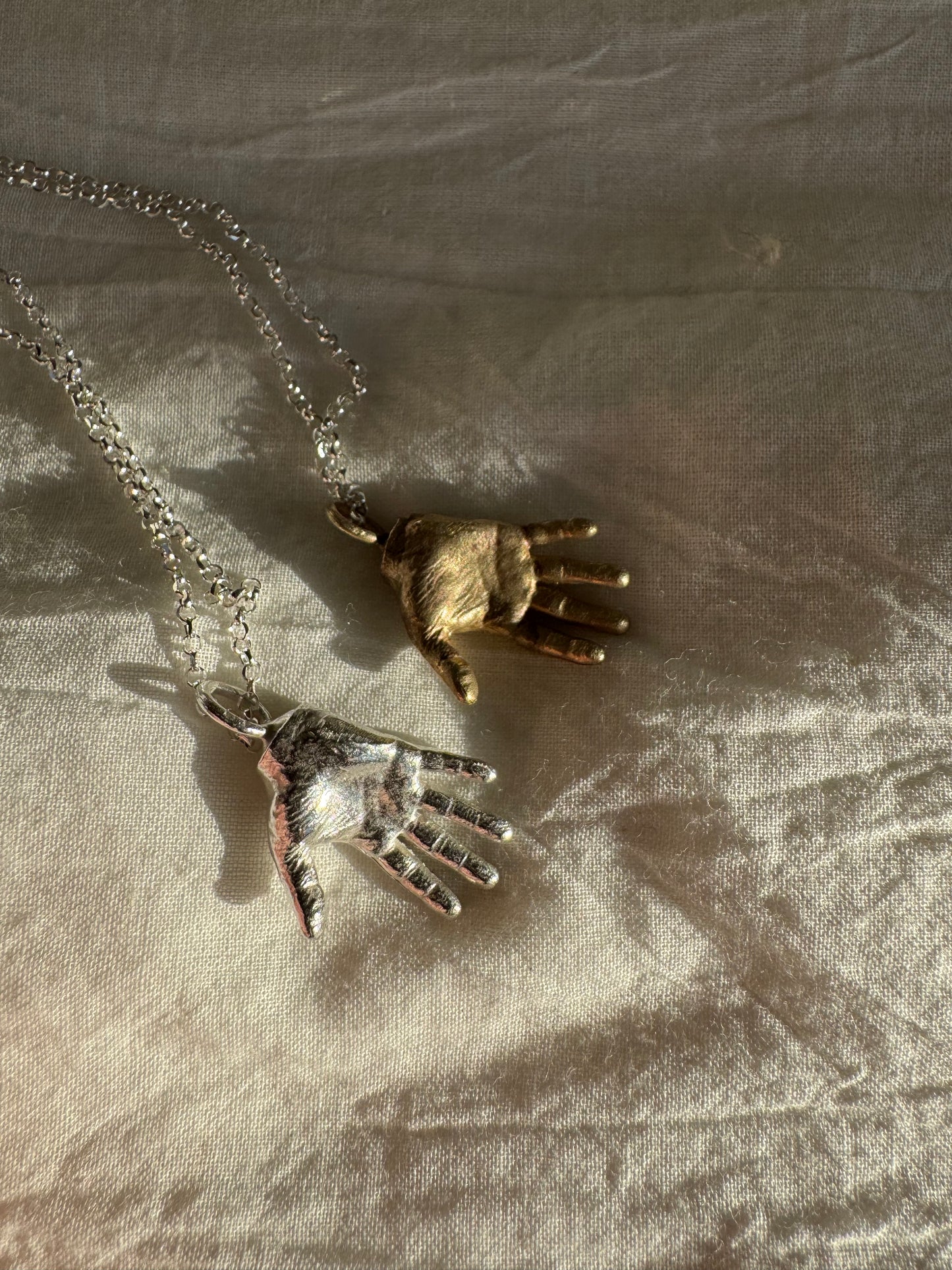 A little Hand charm cast in recycled silver or brass and measuring 2cm by 1.5cm hanging on a 45cm recycled silver chain.