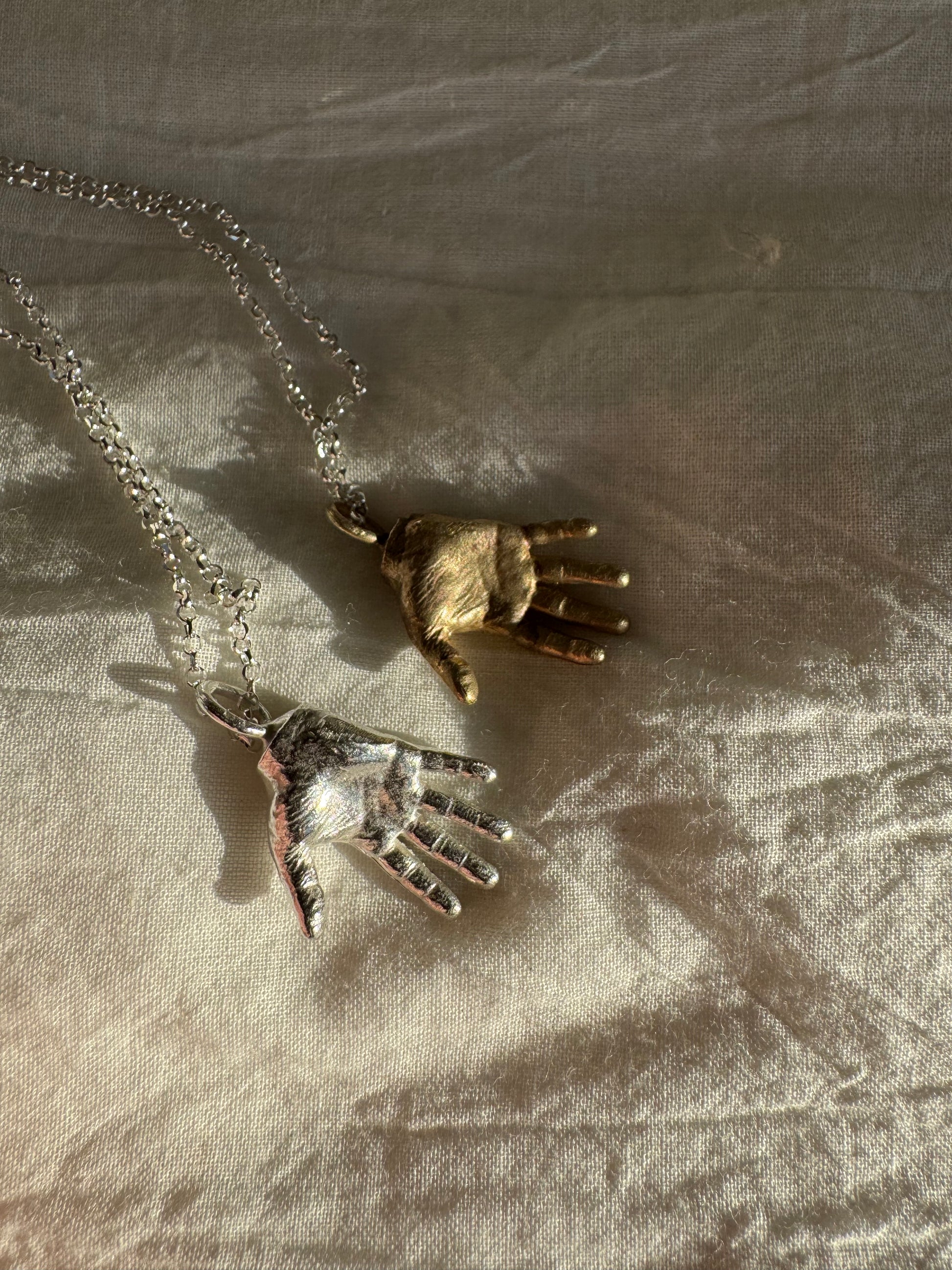A little Hand charm cast in recycled silver or brass and measuring 2cm by 1.5cm hanging on a 45cm recycled silver chain.