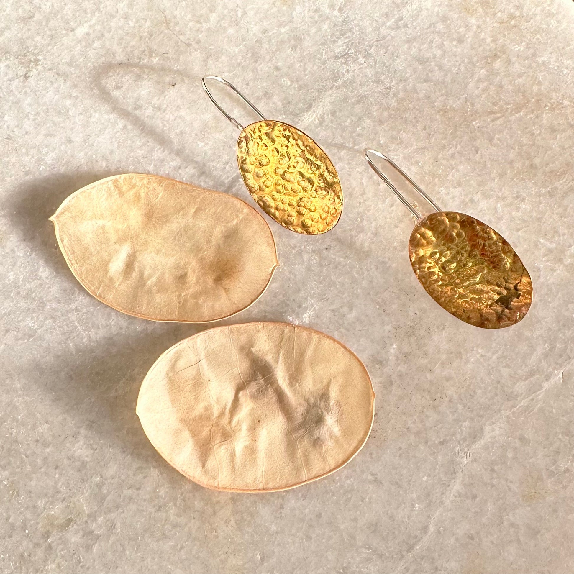HONESTY HOOKS: handmade from sheets of recycled brass, these earrings are honesty seed shaped on recycled silver hook wires. Hand hammered for texture to catch the light.