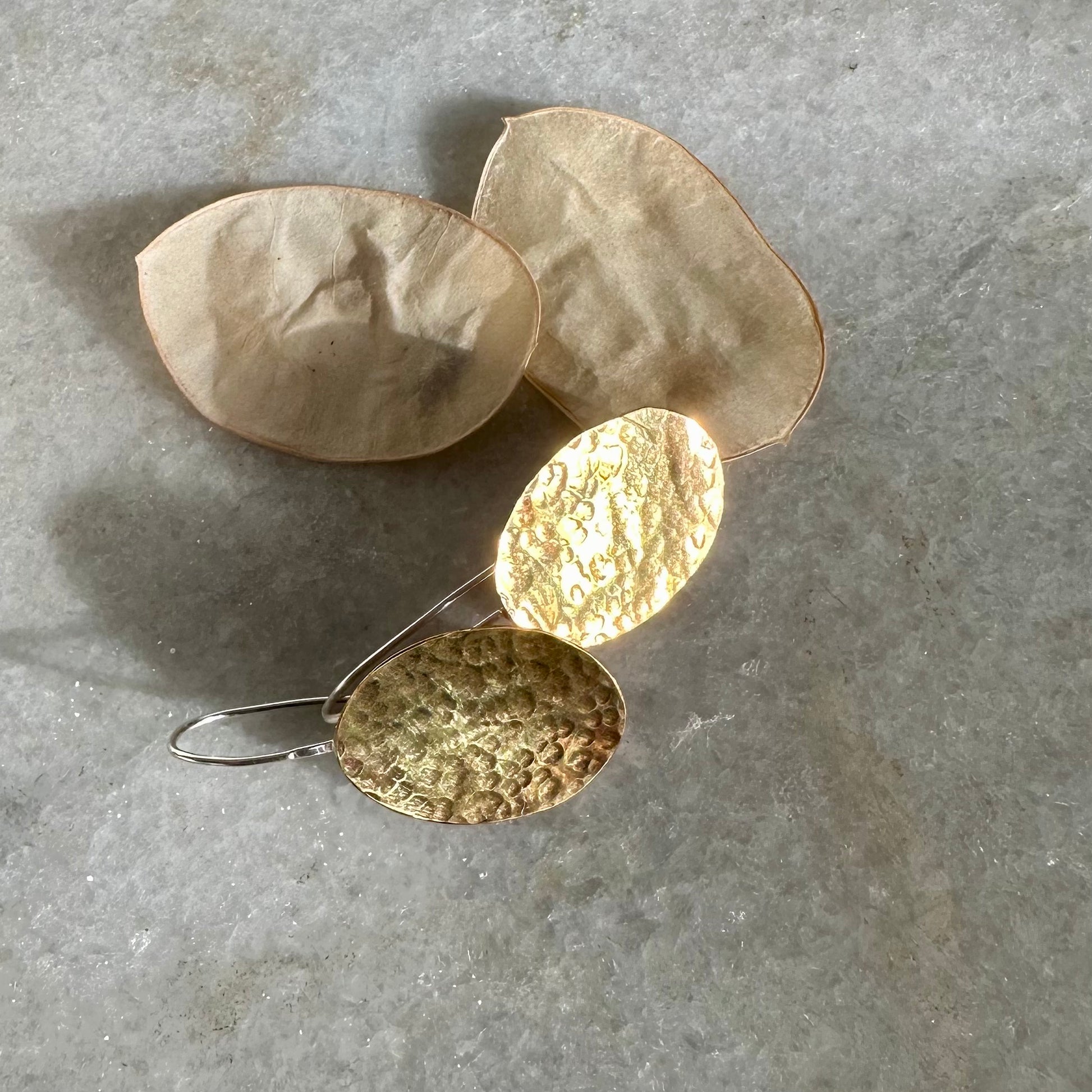 HONESTY HOOKS: handmade from sheets of recycled brass, these earrings are honesty seed shaped on recycled silver hook wires. Hand hammered for texture to catch the light.