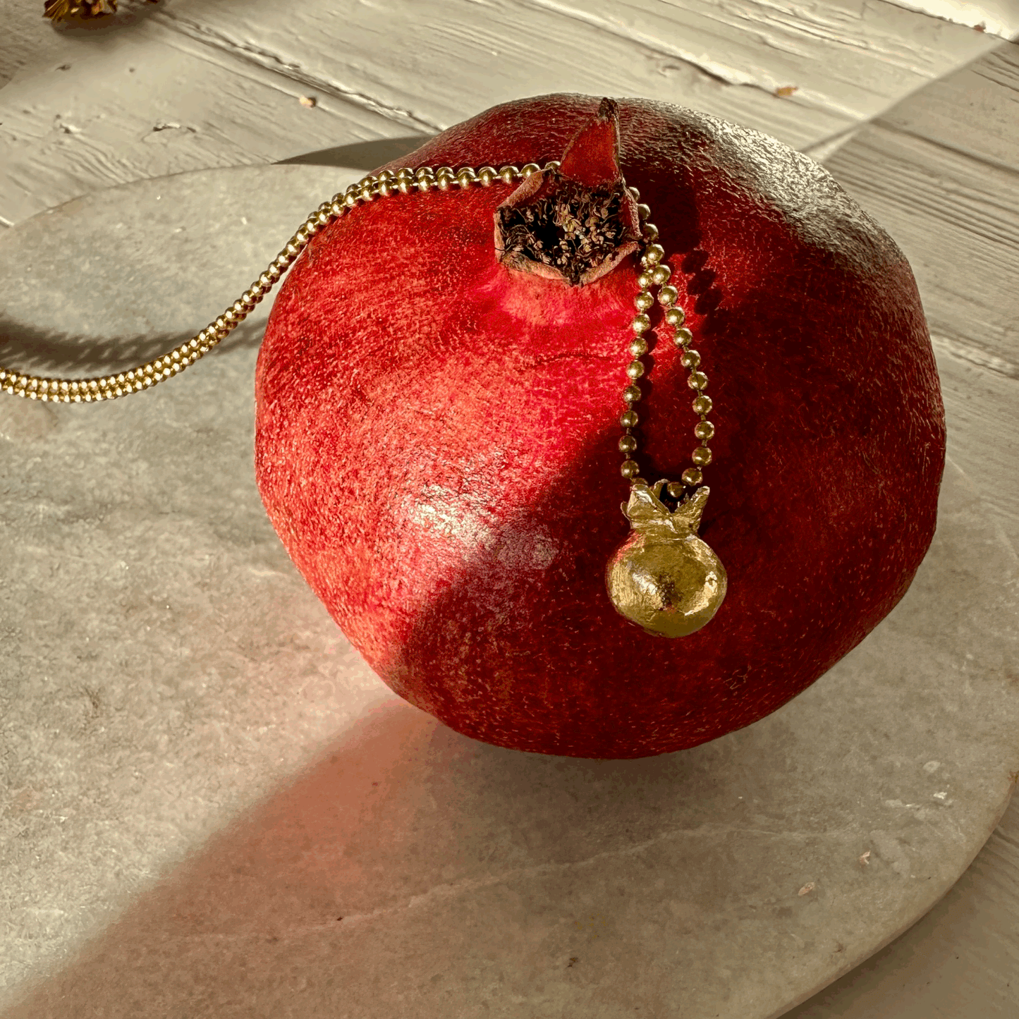 Pomegranate Pendant: A solid recycled brass pomegranate charm on a long brass ball chain.