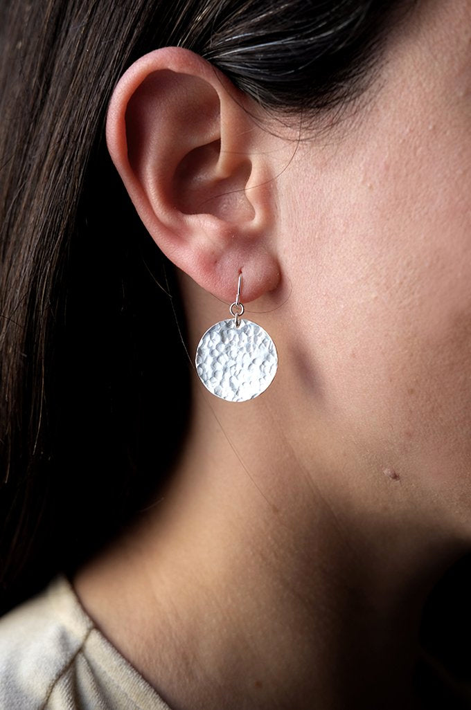 Silver Moons: Handmade recycled silver full moon disc earrings. Worn by a model.