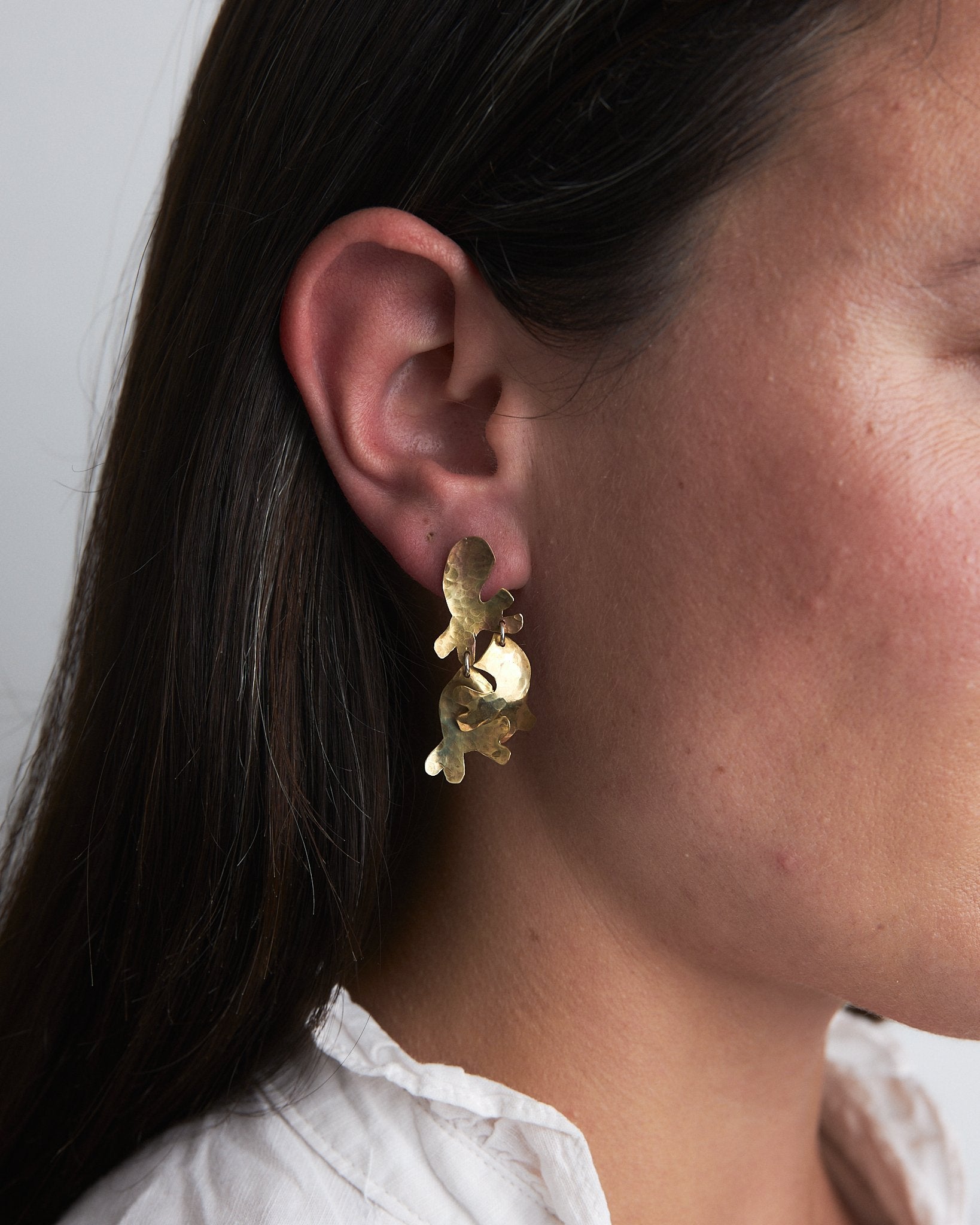 Sea Moss Earrings: handmade recycled brass earrings inspired by the beautiful shapes of sea moss. Worn by a model.