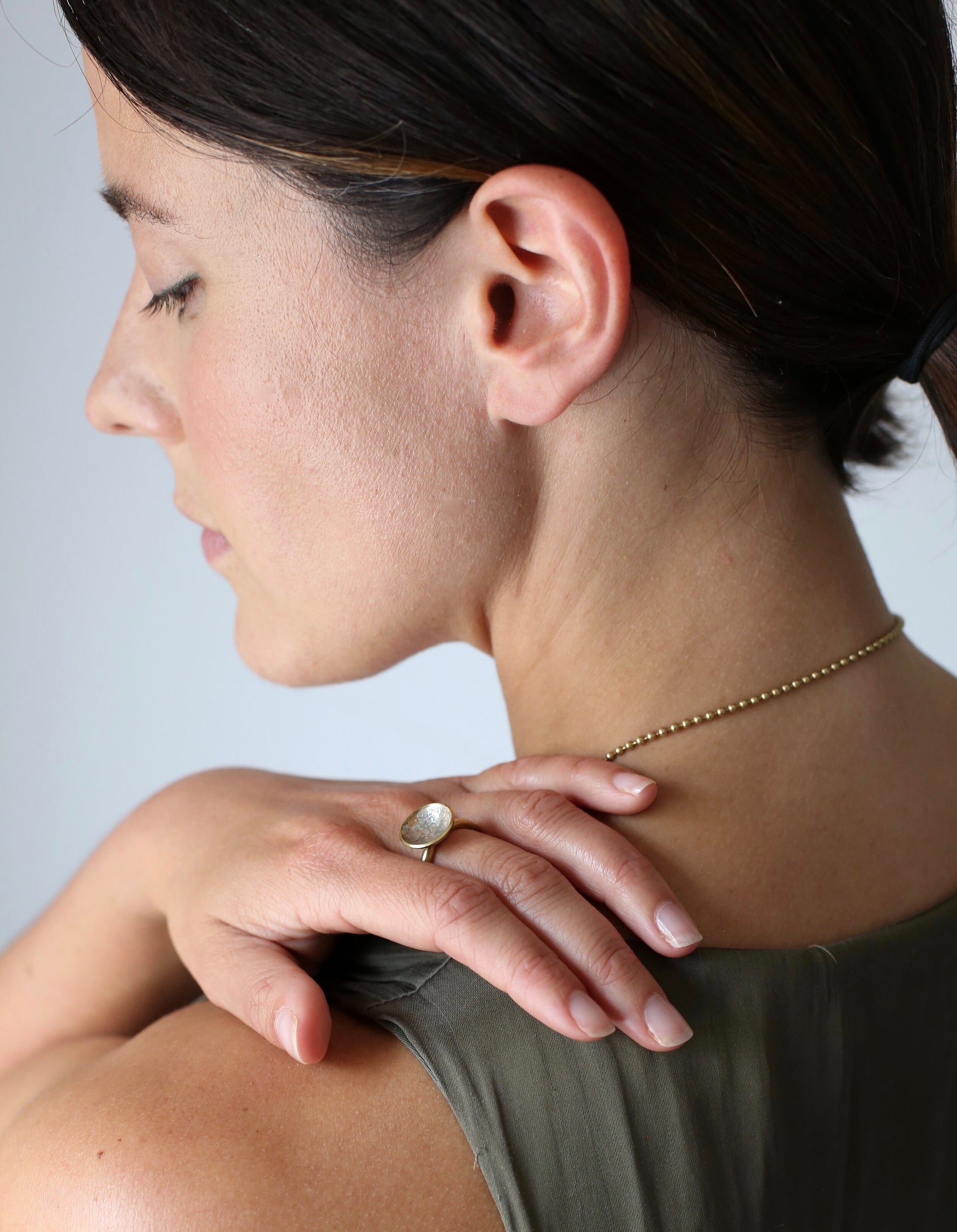 Planet Ring: a handmade brass ring with swirls of molten recycled silver and oxidised silver in a brass cup, worn by a model.