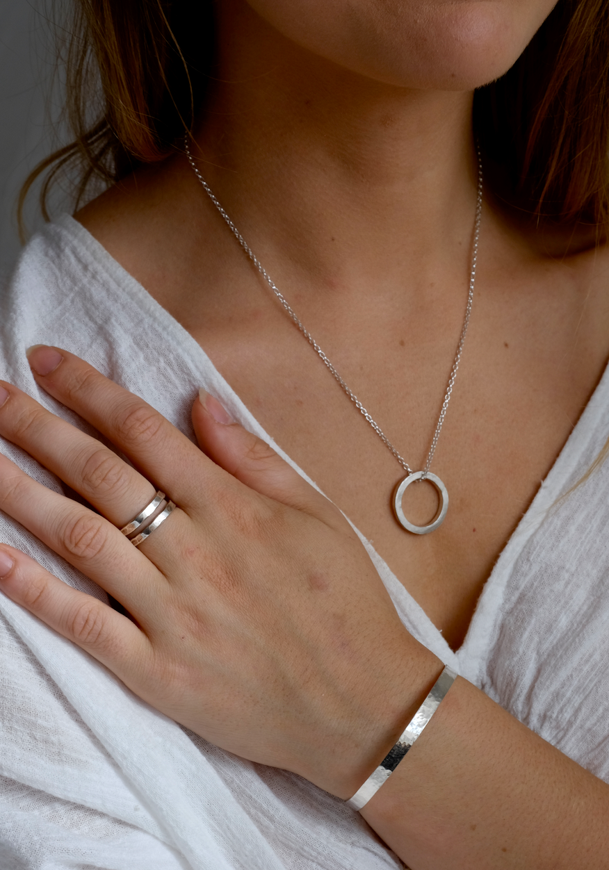 Hammered Silver Spiral Ring: a thicker and textured spiral ring with rounded ends: a spiral of hammered 2.5mm wide recycled silver. Handmade sustainably in Suffolk. Worn by a model.