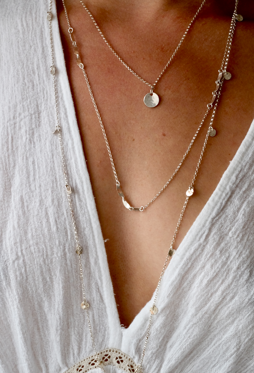 Letty Necklace: a sweet simple necklace with a hand textured recycled silver disc on a recycled silver chain. Worn by a model.
