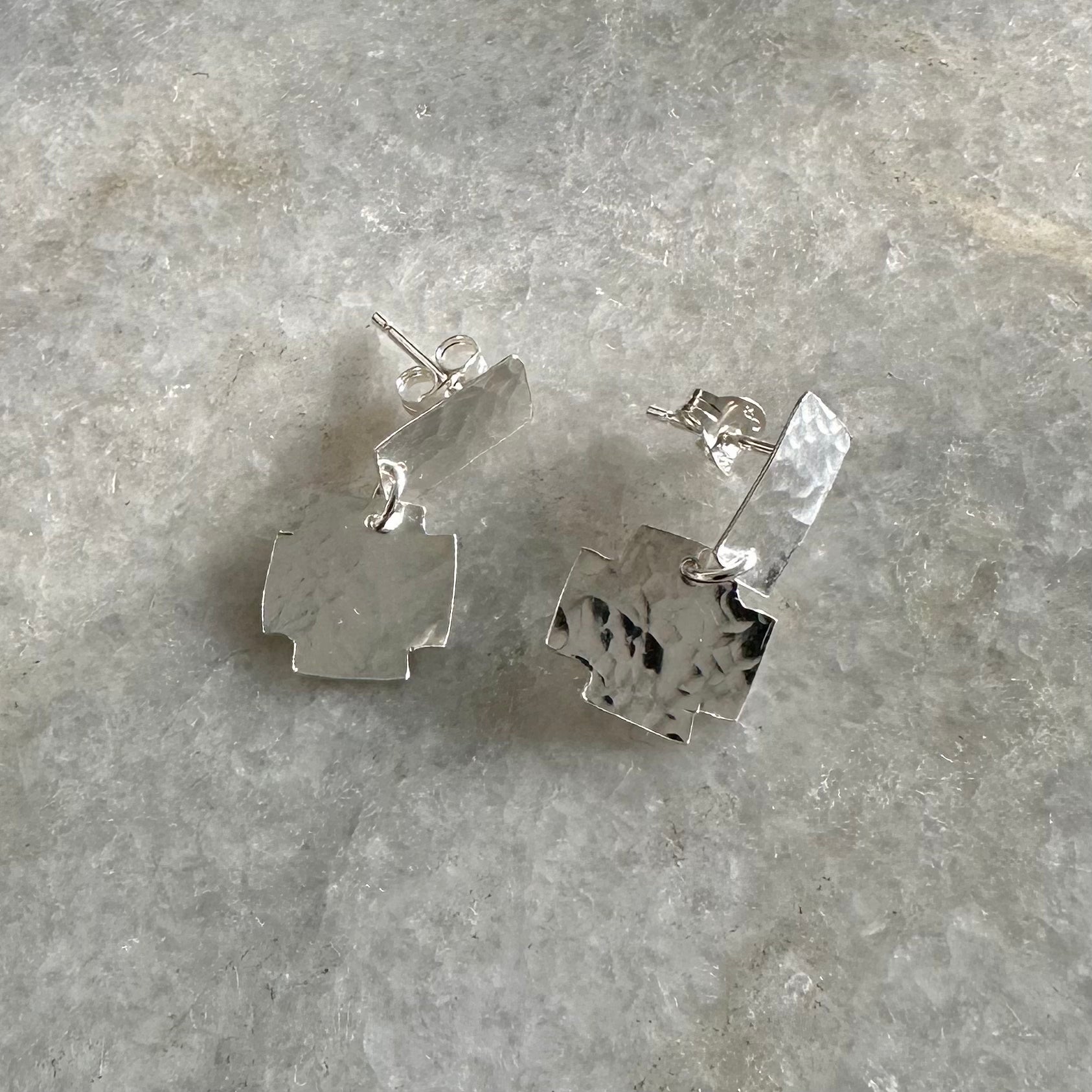 Nell Earrings: gorgeous handmade recycled silver earrings of rectangular and cross shapes. Articulated for movement and to benefit from that inimitable flash of silver. Worn by a model.