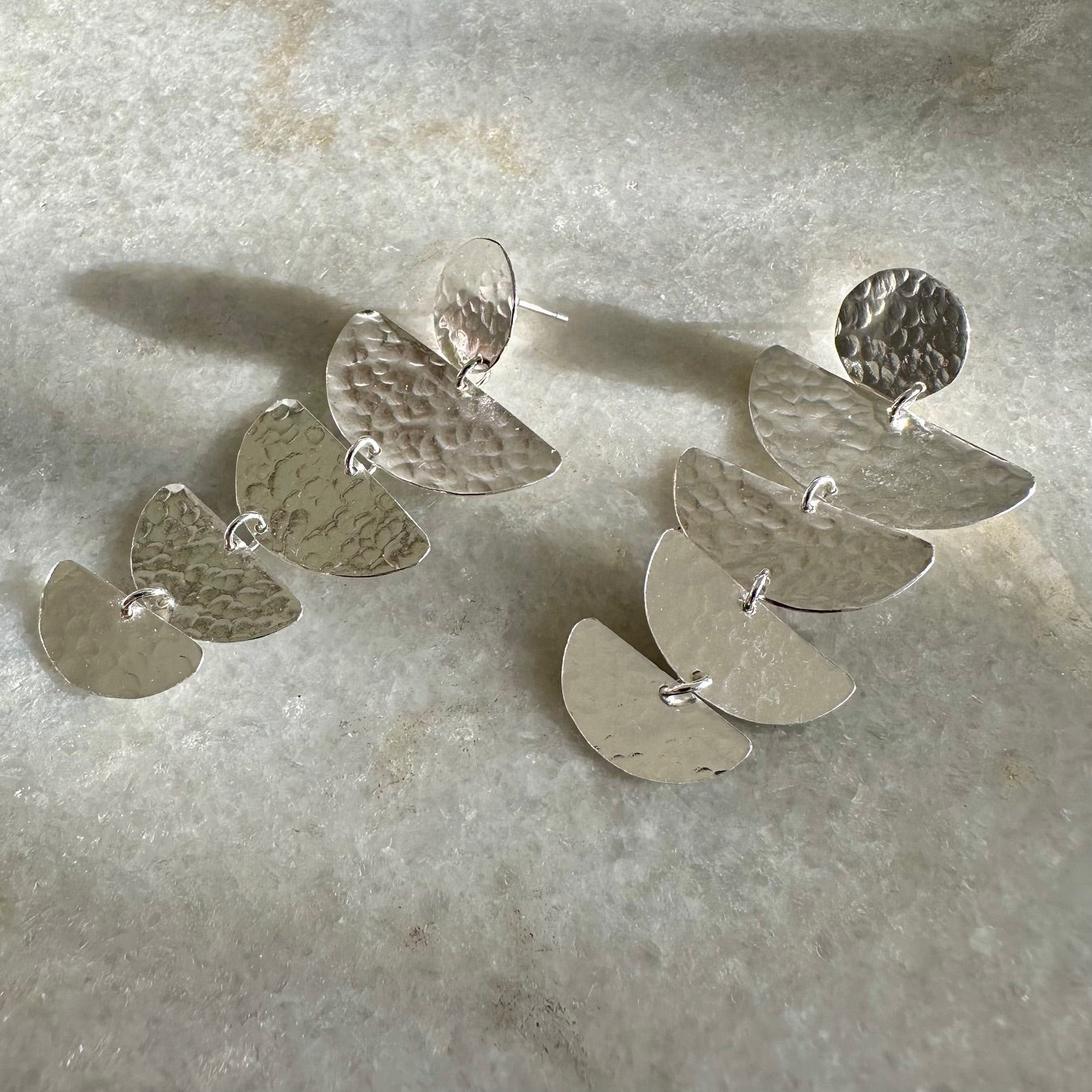 Bella Earrings: handmade with four graduated half moon shapes in recycled silver hanging from a silver disc.