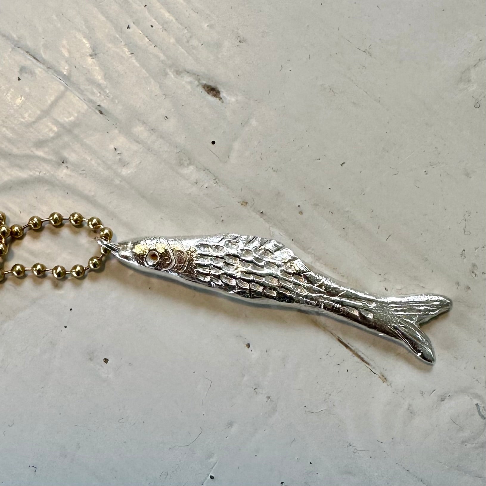 Fish Pendant: A gorgeous solid silver hand carved fish on a brass ball chain.