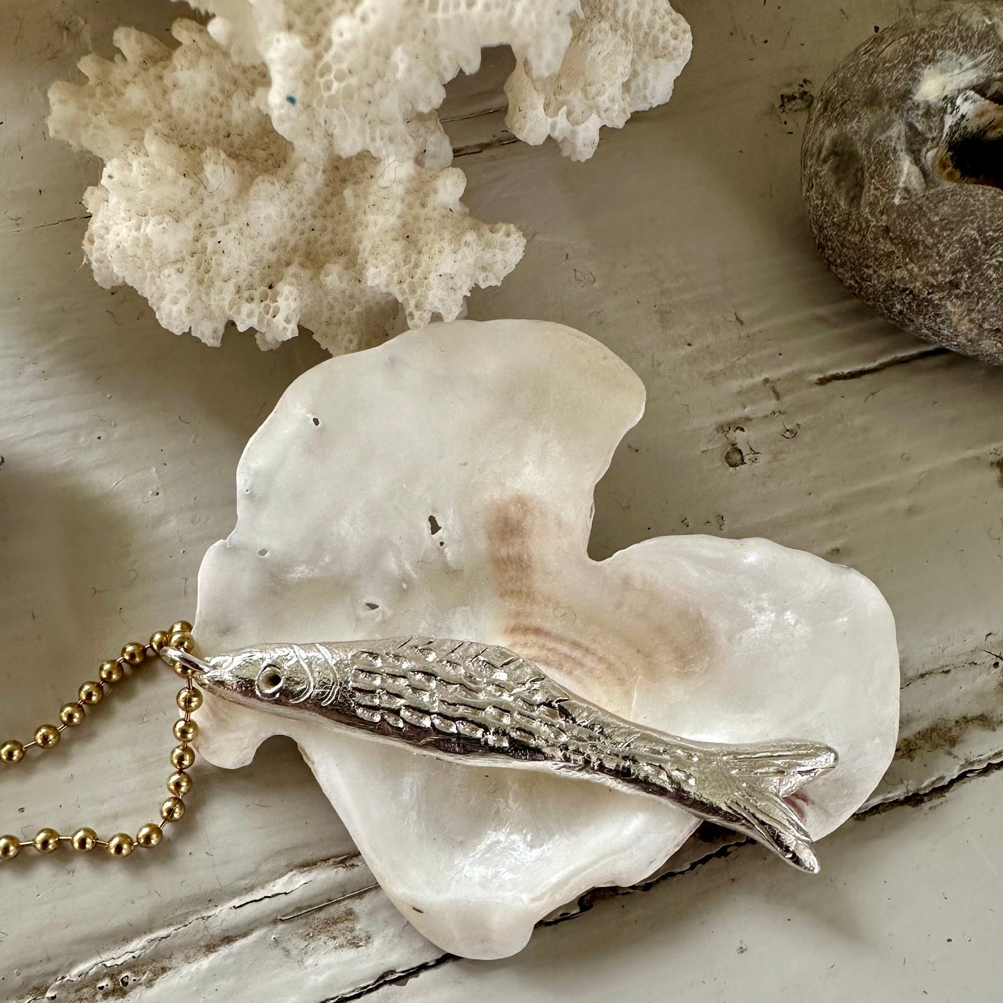 Fish Pendant: A gorgeous solid silver hand carved fish on a brass ball chain.