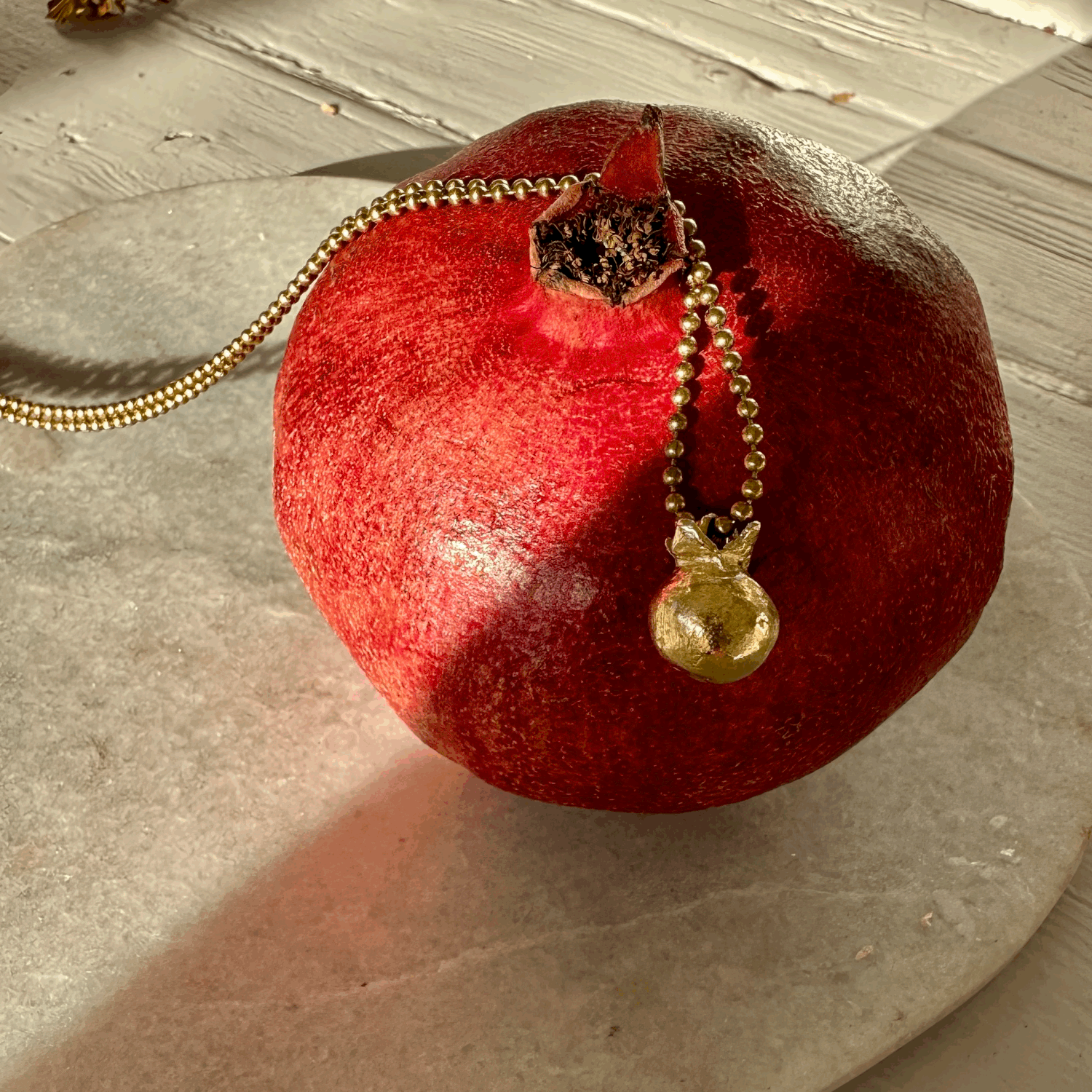Pomegranate Pendant: A solid recycled brass pomegranate charm  on a long brass ball chain.