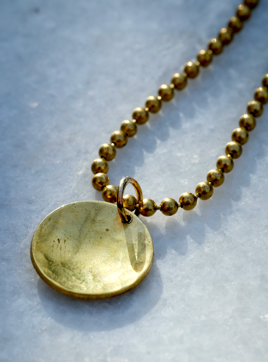 Sunny Pendant: a gorgeous pendant with a tactile hammered and slightly domed brass disc on a vintage brass ball chain - inspired by the sun.  Handmade sustainably in Suffolk.