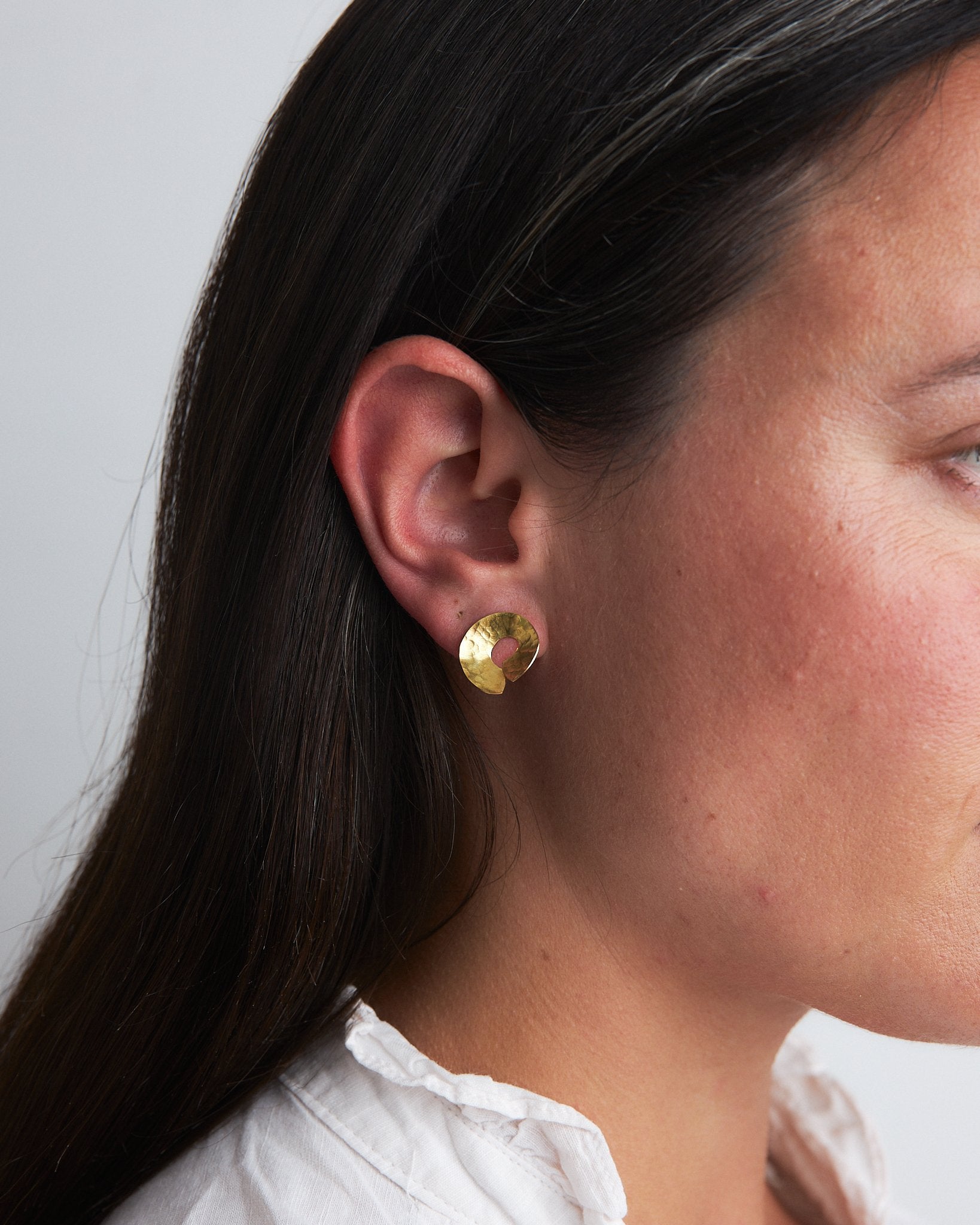 Codium Studs: handmade earrings in recycled brass, based on the shape of the ends of codium seaweed. Worn by a model.