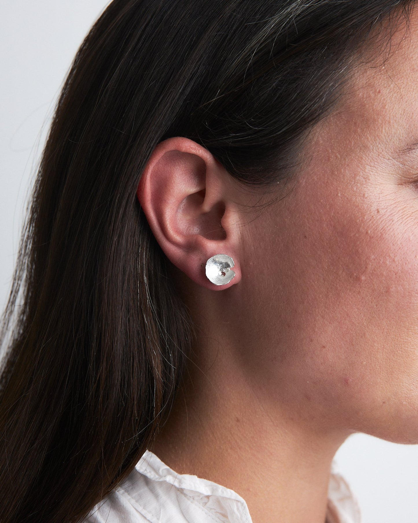 Ponds Studs: beautiful handmade organically shaped and domed recycled silver stud earrings. Worn by a model.