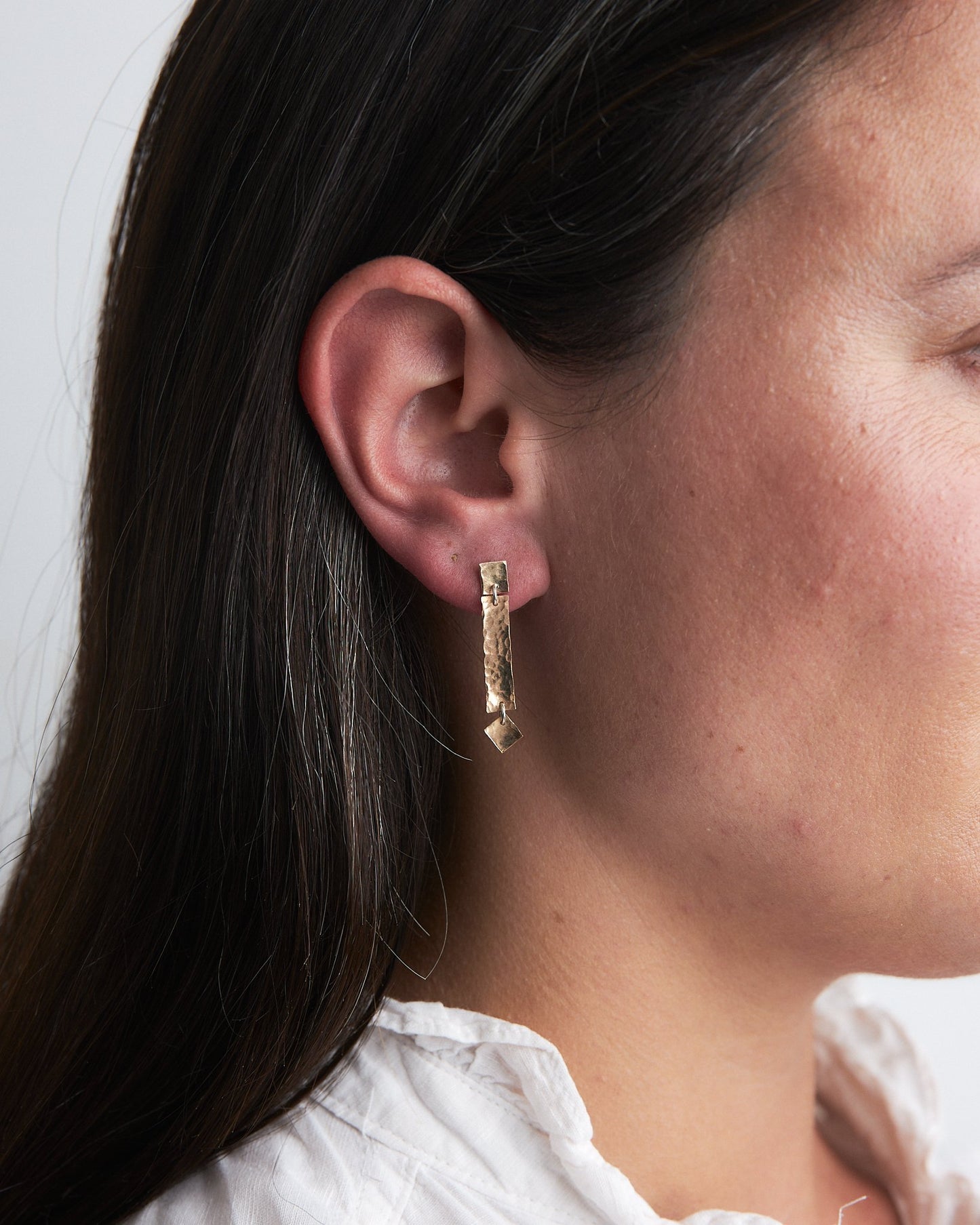 Martha Earrings: handmade in recycled gold consisting of delicate squares and rectangles - subtle and shimmery. Worn by a model.