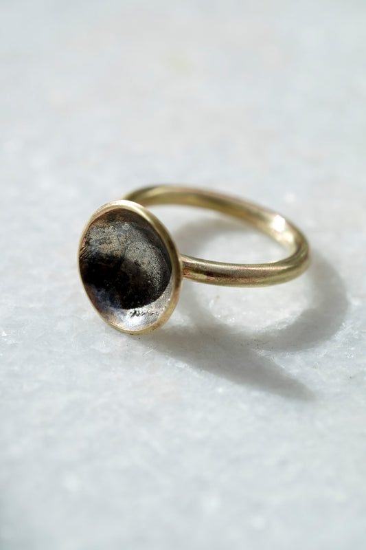 Planet Ring: a handmade brass ring with swirls of molten recycled silver and oxidised silver in a brass cup