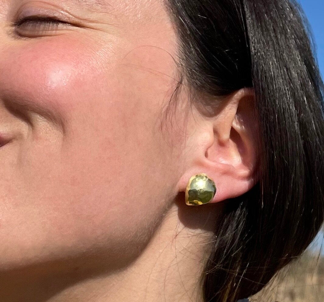 Artichoke Studs: handmade domed artichoke leaves in recycled brass, worn by a model.