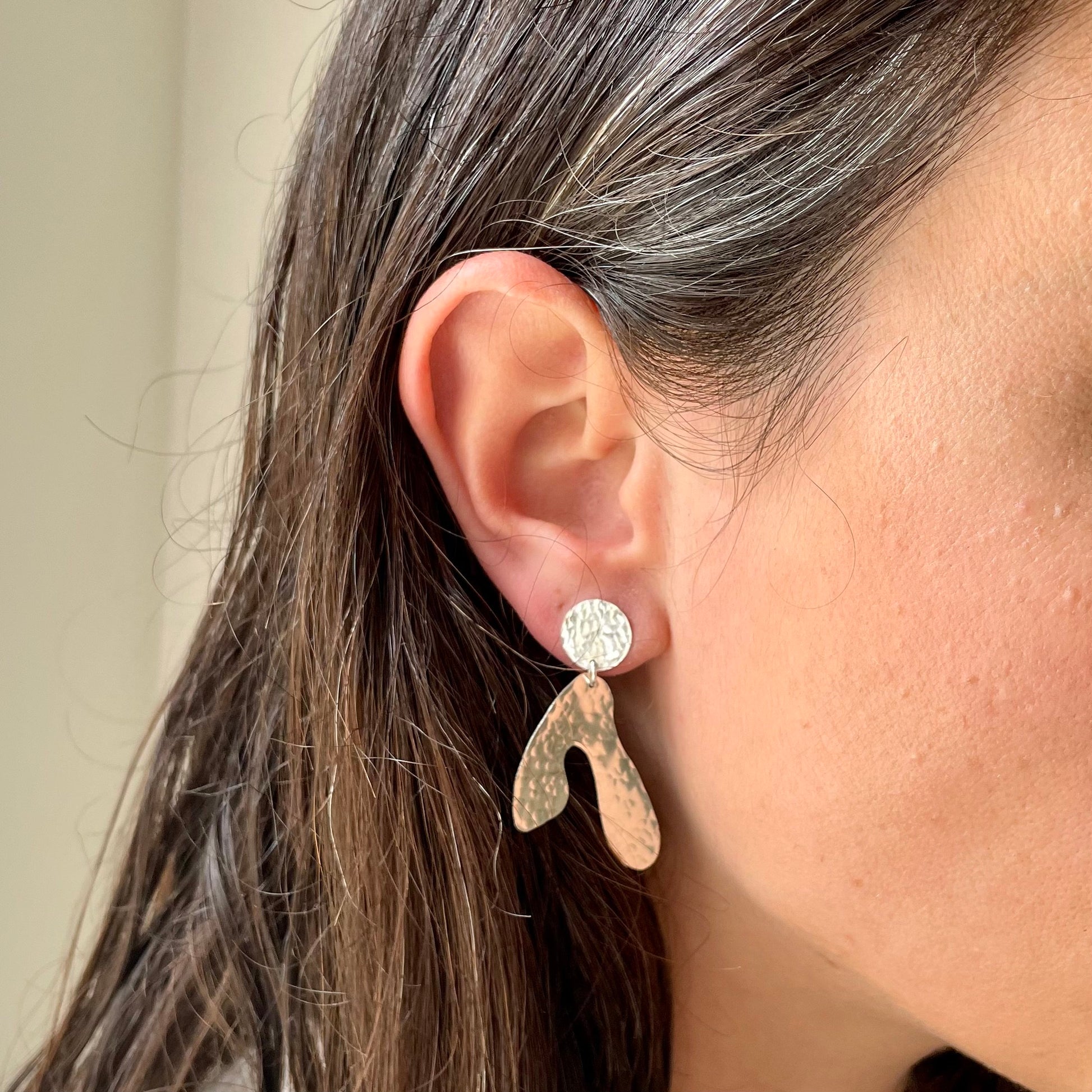 Sycamore Earrings: sycamore seed shaped earrings handmade in recycled silver, worn by a model.