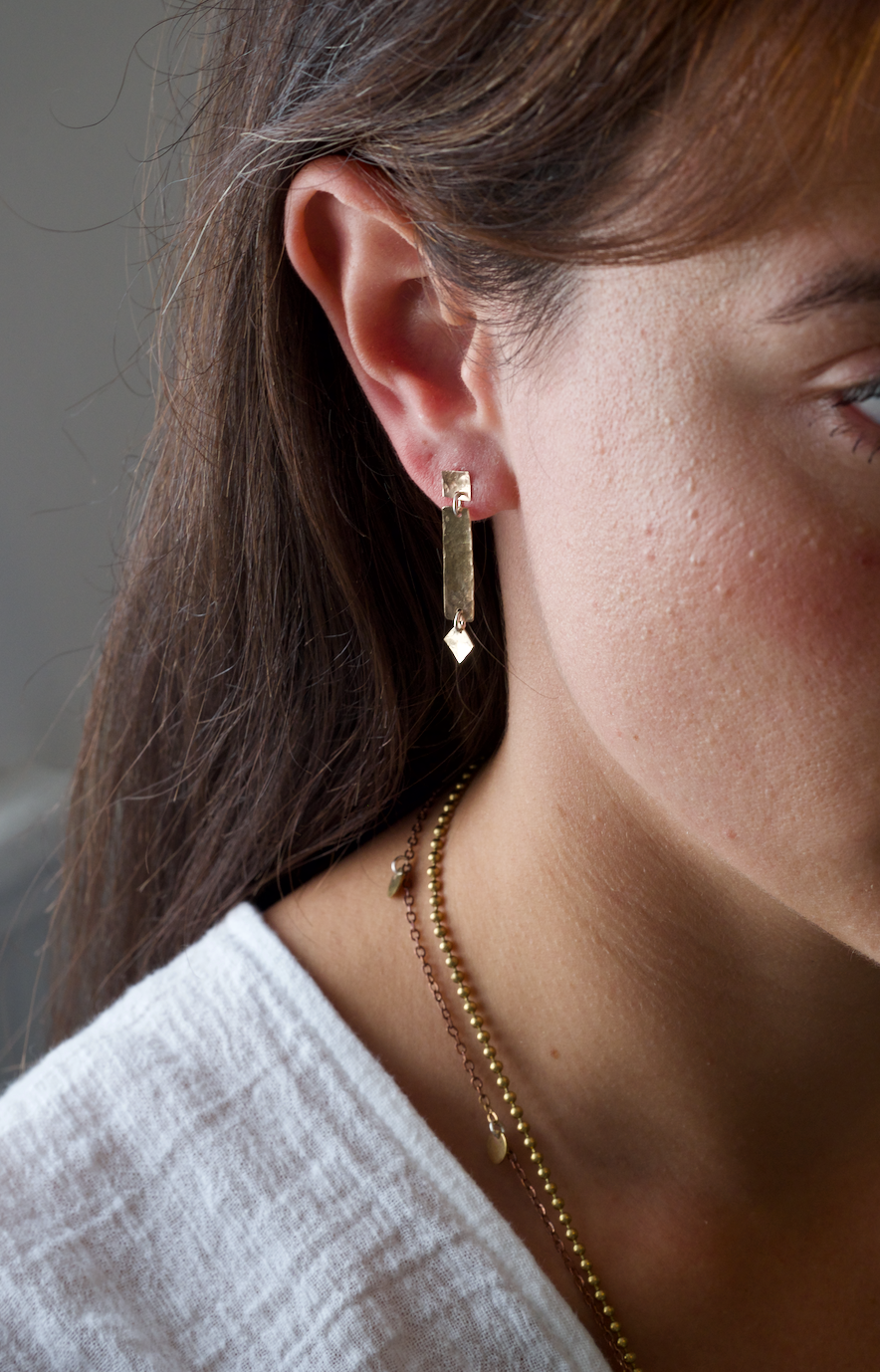 Martha Earrings: handmade in recycled gold consisting of delicate squares and rectangles - subtle and shimmery. Worn by a model.