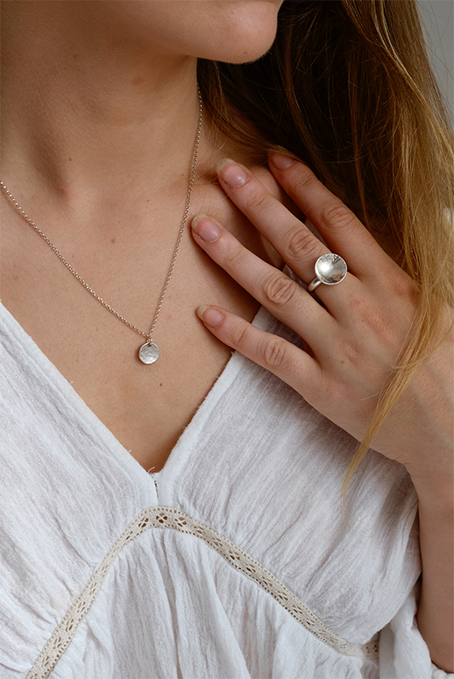 Silver Moon Ring: a lovely chunky ring handmade from recycled silver with a slightly concave domed and hammered disc on a solid recycled silver ring shank. Inspired by the moon. Worn by a model.