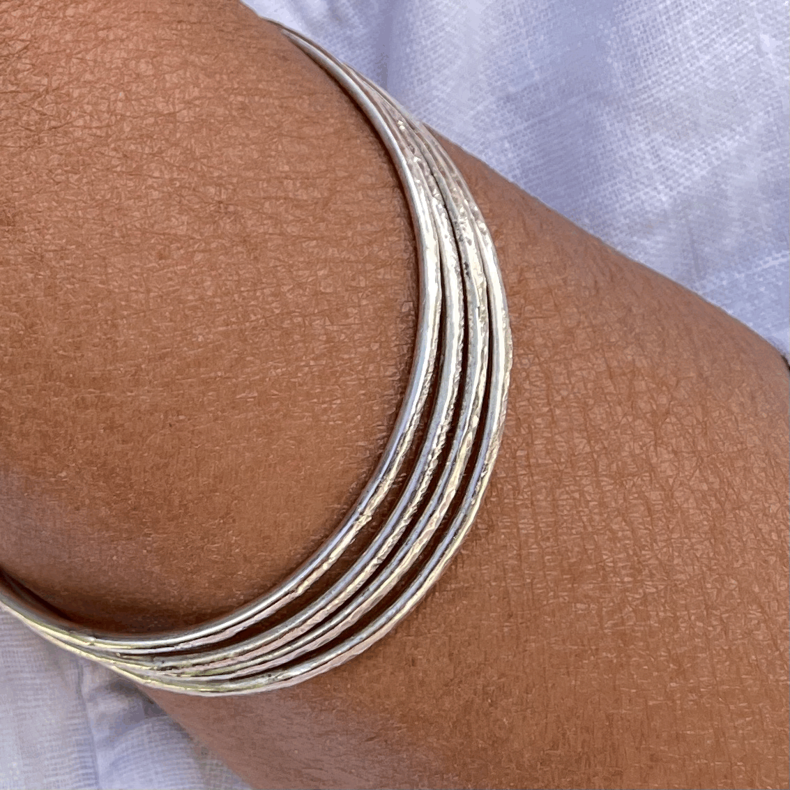Textured Bangle: A handmade textured sturdy bangle in recycled silver, worn by a model.