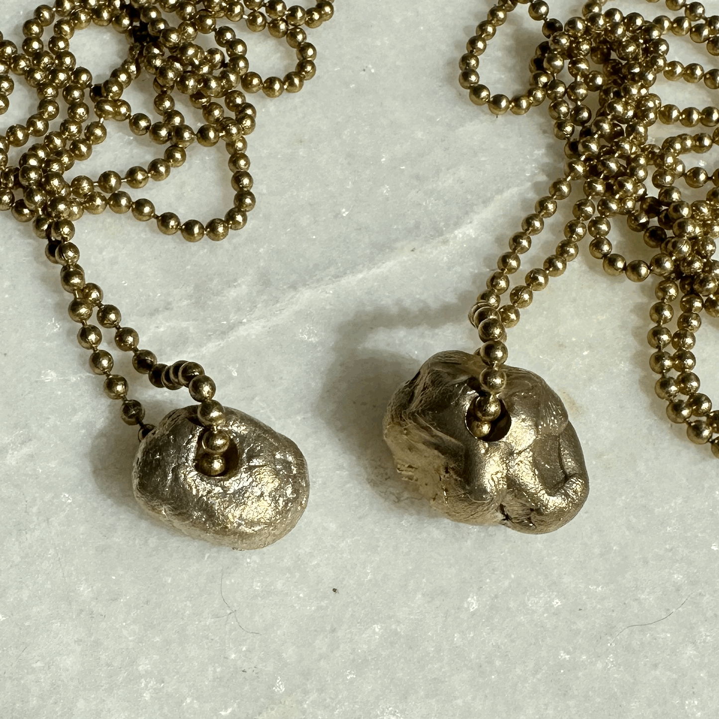 Brass Hag Stone Pendants in two sizes.